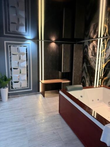a bathroom with a tub and a table and a bench at Regim Hotel Hanea jacuzzi in camera,piscina exterioara si sauna comuna in Sibiu
