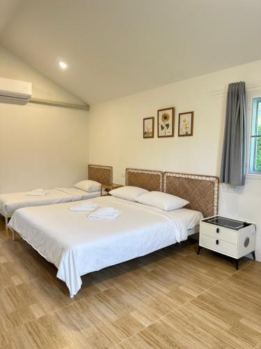 two beds sitting in a room with at โรงแรมซุนเซนโฮมแอนด์คาเฟ่ in Ban Na Lao