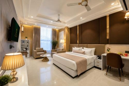 a hotel room with a bed and a desk at Hotel Aroma Suites Delhi - With Free Airport Drop in New Delhi