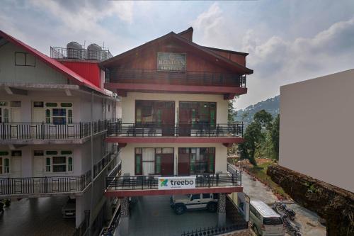 a building with a sign on the side of it at Treebo Roshan House Near Mcleodganj in McLeod Ganj