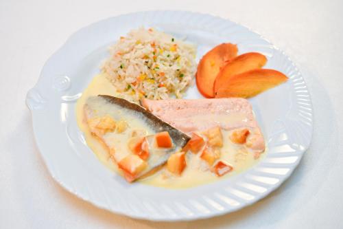 a white plate of food with rice and vegetables at Hotel Berghaus in Wengen