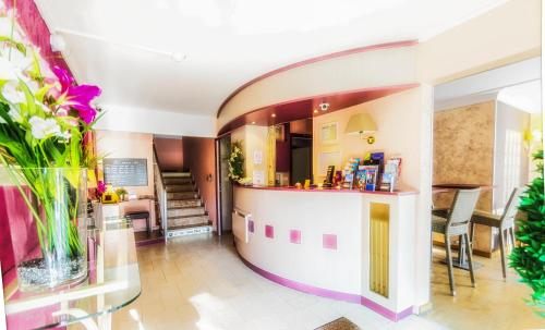 une cuisine et une salle à manger avec une table et des chaises dans l'établissement Hôtel PRADO avec Parking - Proche Zénith, à Toulouse