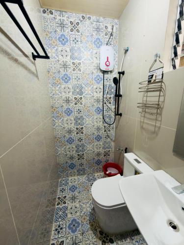 a bathroom with a toilet and a sink and a shower at Skys Transient House Unit 1 in Manolo Fortich
