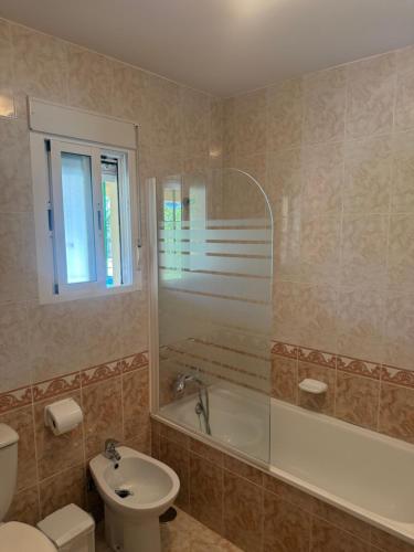 a bathroom with a toilet and a tub and a sink at Traumhaus für 6 Personen mit spektakulärem privaten Pool und schönem Ausblick in die Natur in Hozanejos