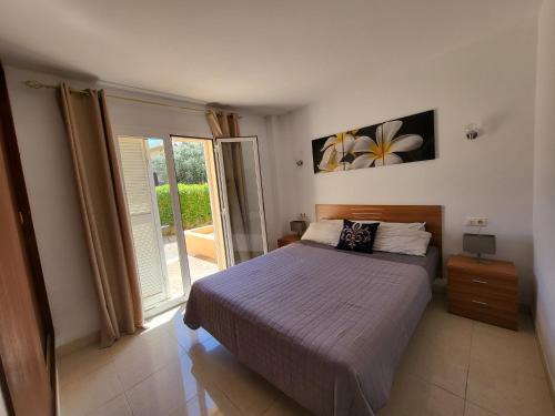a bedroom with a bed and a sliding glass door at Ferienwohnung Lika in Cala Bona