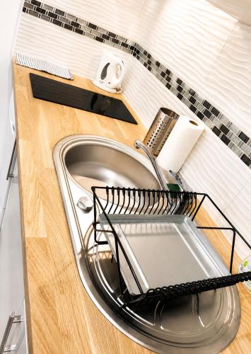a metal sink with a strainer on top of it at Les Escales de Choisy in Choisy-le-Roi