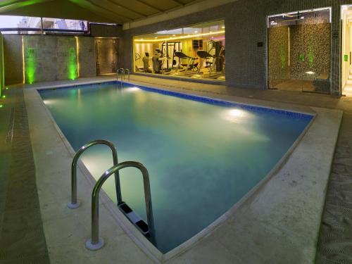 a large swimming pool in a gym with two metal at Novotel Suites Riyadh Olaya in Riyadh