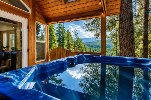 a tub in a cabin with a view of the forest at Das Tree Haus by NW Comfy Cabins in Leavenworth