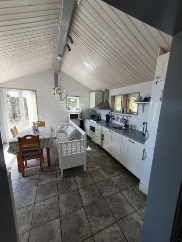 a kitchen with white cabinets and a table and a tableablish at Lillstugan at Sävö in Västerljung