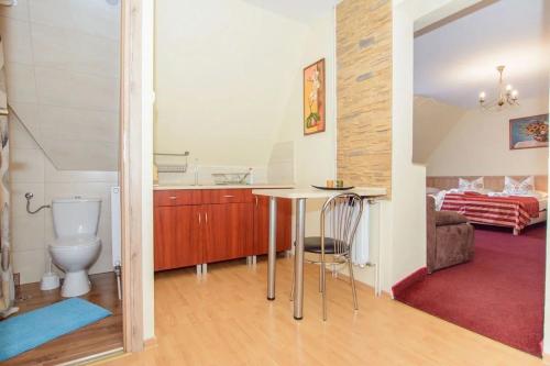 a bathroom with a toilet and a table in a room at Willa za Wodą in Zakopane