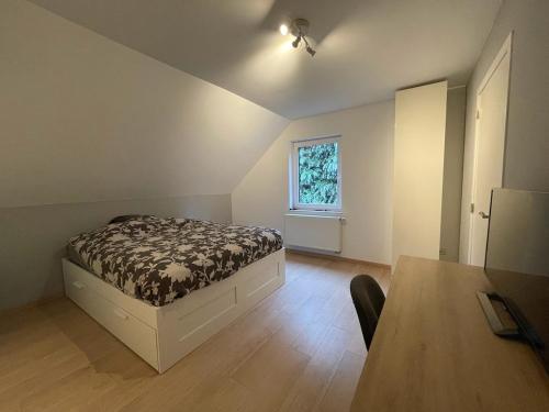 a bedroom with a bed and a table and a window at Maison avec piscine à Dinant in Sorinnes