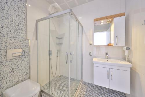 a bathroom with a shower and a toilet and a sink at Sardunya Andifli Otel in Kaş