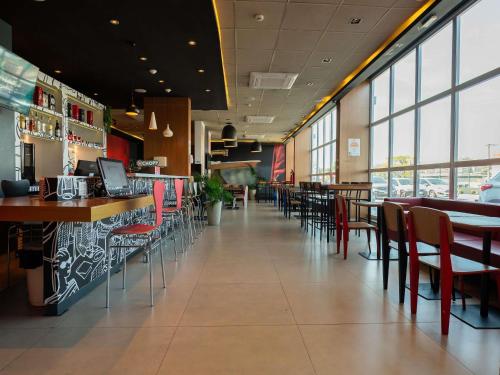a dining room with tables and chairs in a restaurant at Ibis Guaratingueta Aparecida - Circuito da Fé in Guaratinguetá