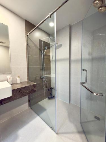 a glass shower in a bathroom with a sink at Lia Home in Sapa