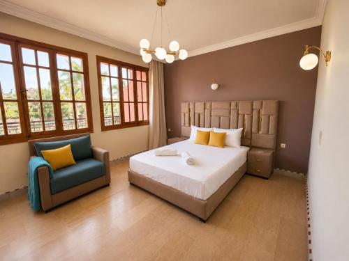 a bedroom with a bed and a blue chair at Elegant, quiet villa in Marrakesh