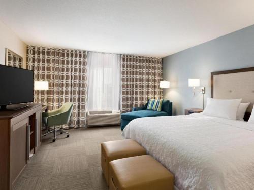a hotel room with a bed and a television at Hampton Inn Bartow in Bartow