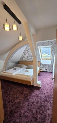 a bedroom with a bed in a room with a purple carpet at Hotel Vacek Pod Věží in Hradec Králové