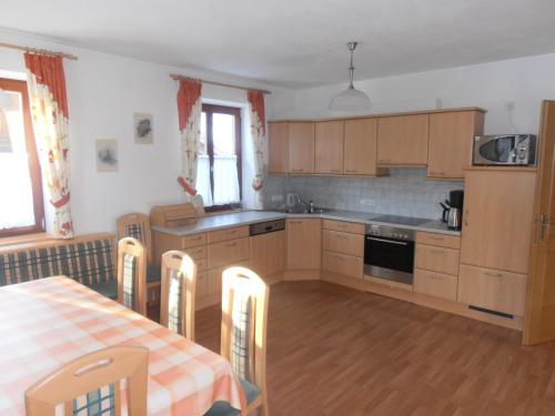 una cocina con armarios de madera y una mesa con mantel. en Puellgut, en Flachau