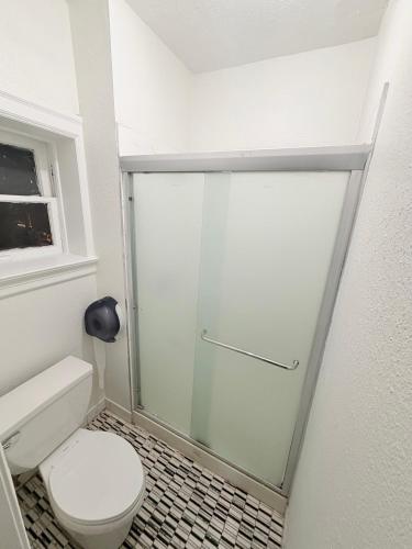 a bathroom with a toilet and a glass shower door at Adrian Hotel in San Francisco