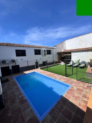 a swimming pool in a yard with a house at CASA RURAL LA CARRIONA in Segura de León