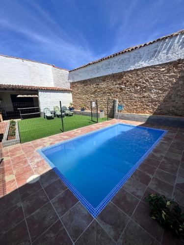 a large blue swimming pool in front of a building at CASA RURAL LA CARRIONA in Segura de León