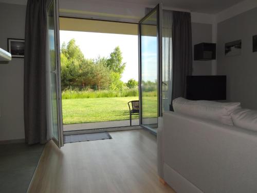 a bedroom with a sliding glass door with a view of a yard at Bajkowa Plaża - Muszelka in Gdańsk
