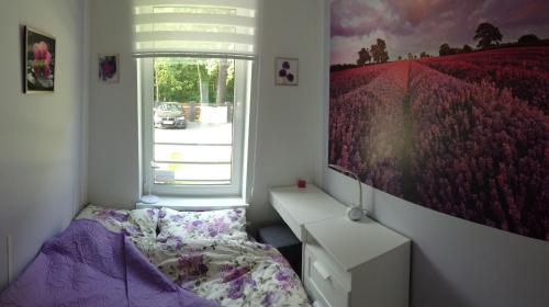 a bedroom with a bed and a large painting on the wall at Bajkowa Plaża - Muszelka in Gdańsk
