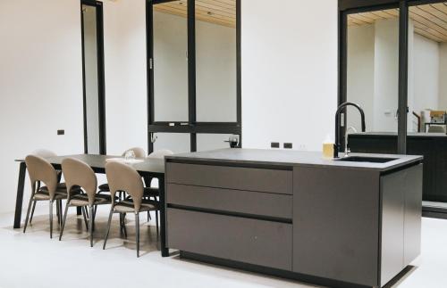 a kitchen with a sink and a table with chairs at Chungi Hotel 純吉民宿 咖啡 in Xincheng