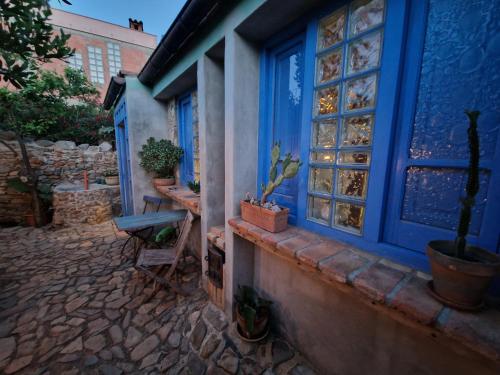 a blue building with potted plants and a window at Casa Olive in San Vito