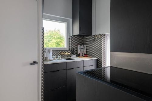 a kitchen with a sink and a window at Villa COCO Chanel Kamer in Noordwijk