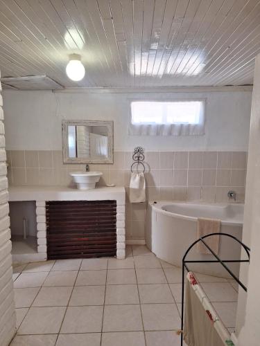 a large bathroom with a tub and a sink at Blanco Guest Farm - Holiday Resort in Tarkastad