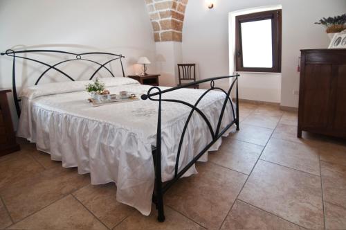 a bedroom with a bed with a white comforter at Home Holiday Salento Casa Agrosì Don Camillo in Presicce