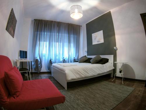 1 dormitorio con 1 cama y 1 silla roja en B&B Piccinni 191, en Bari