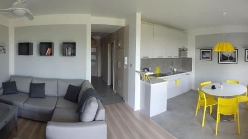 a living room and kitchen with a couch and a table at Bajkowa Plaża - Amber in Gdańsk