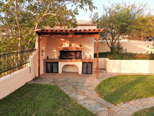 a fireplace in a backyard with a gazebo at Villa Christina in Anavissos