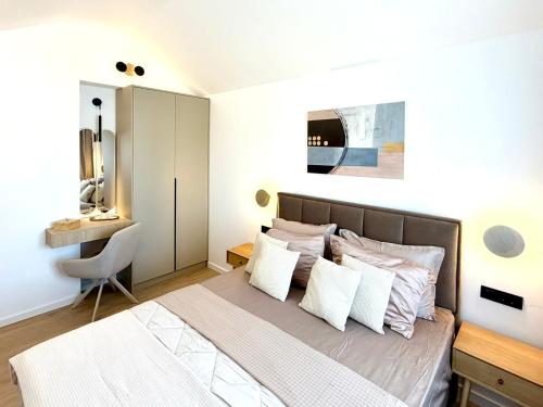 a bedroom with a bed with white walls and a desk at Villa Tina Luxury Suite Newly Renovated 2026 in Novigrad Istria