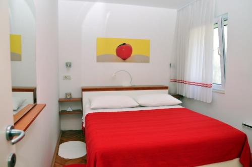 a bedroom with a red bed with a red blanket at BM Apartments Split in Split