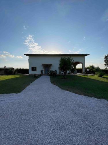 a large white building with a gravel driveway at Casale Country Chic- Sabaudia in Borgo Isonzo