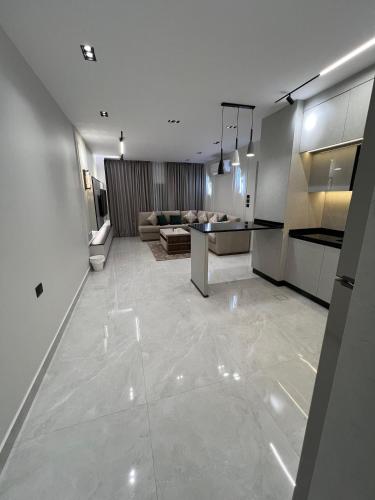a large living room with a kitchen and a living room at Hodoon Apartments in Amman