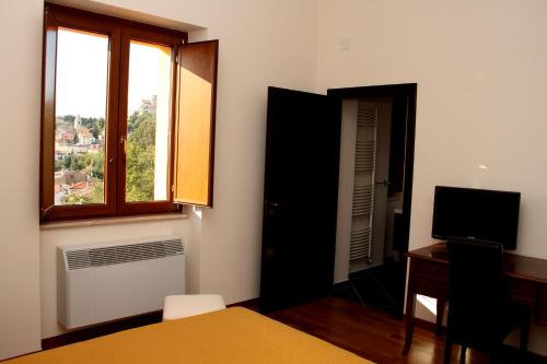 a bedroom with a window and a desk and a television at Affittacamere Bellavista in San Marco dei Cavoti