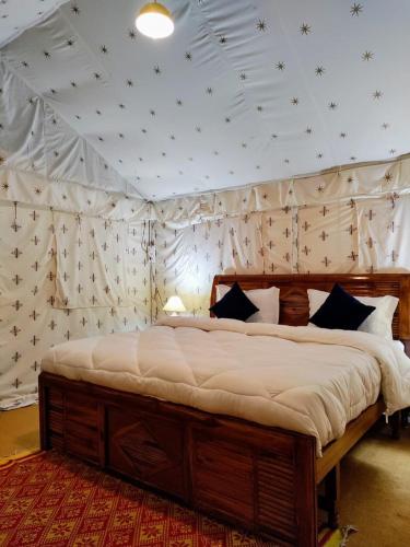 a bedroom with a large bed in a tent at Omya Forest Camps & Cottages Bir, Near Choti Machiyal in Bīr