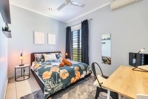 a bedroom with a bed and a tv and a table at The Skyline Lookout Pool, BBQ, FREE parking in Stuart Park