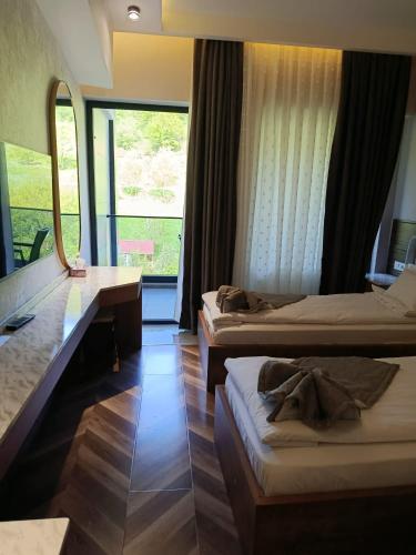 a hotel room with two beds and a large window at Heaven resort hotel in ToÄŸanalÄ±
