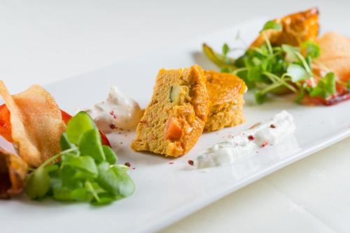 a white plate with food on it with salad at Ferienhaus Alpen Lodge und die Gams in Neurur