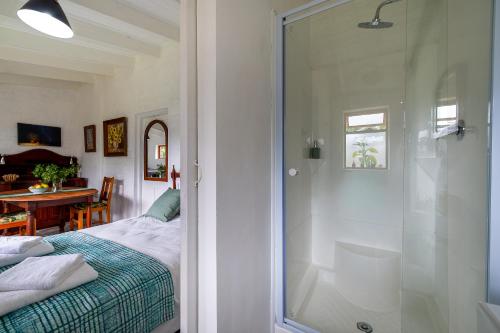 a bathroom with a shower and a bedroom with a bed at Disselblom Cottage in Sedgefield
