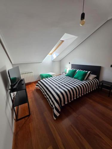a bedroom with a large bed with green pillows at Sweet Dreams Úbedas in Talavera de la Reina