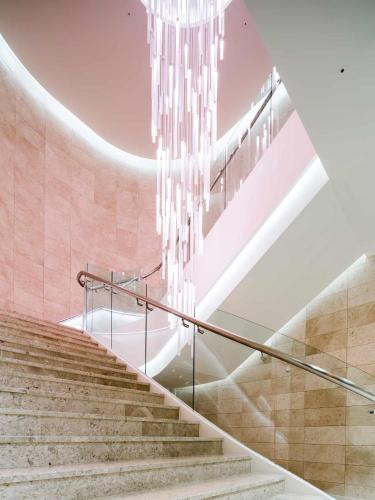 a staircase with a chandelier in a building at Novotel Ambassador Suwon in Suwon