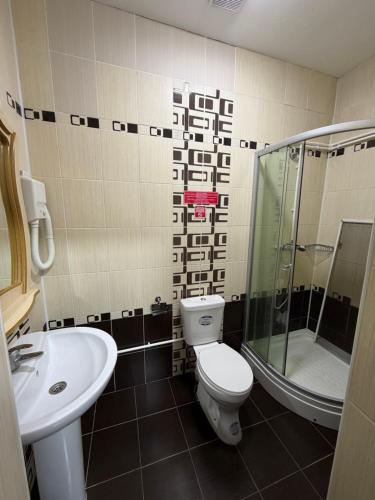 a bathroom with a toilet and a shower and a sink at Rif Burabay in Borovoye