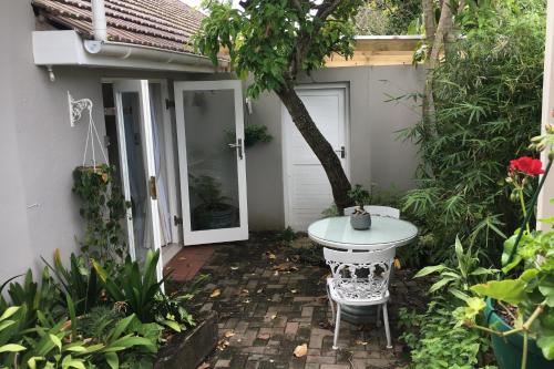a small patio with a table and a door at Pollock's B&B in East London