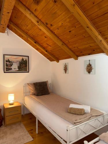 a bed in a room with a wooden ceiling at Villa Solis Sarajevo Private Pool Jacuzzi in Sarajevo